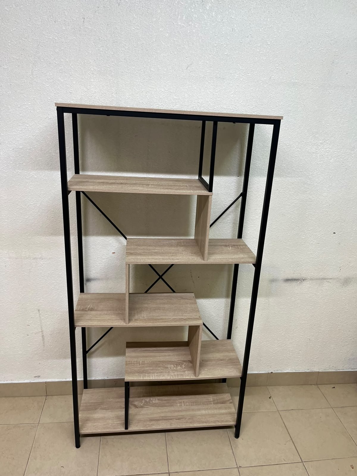 A shelving unit featuring a modern industrial design, consisting of a sturdy black metal frame and natural-look wooden shelves arranged in a tiered, graduated-width layout. - Image 4