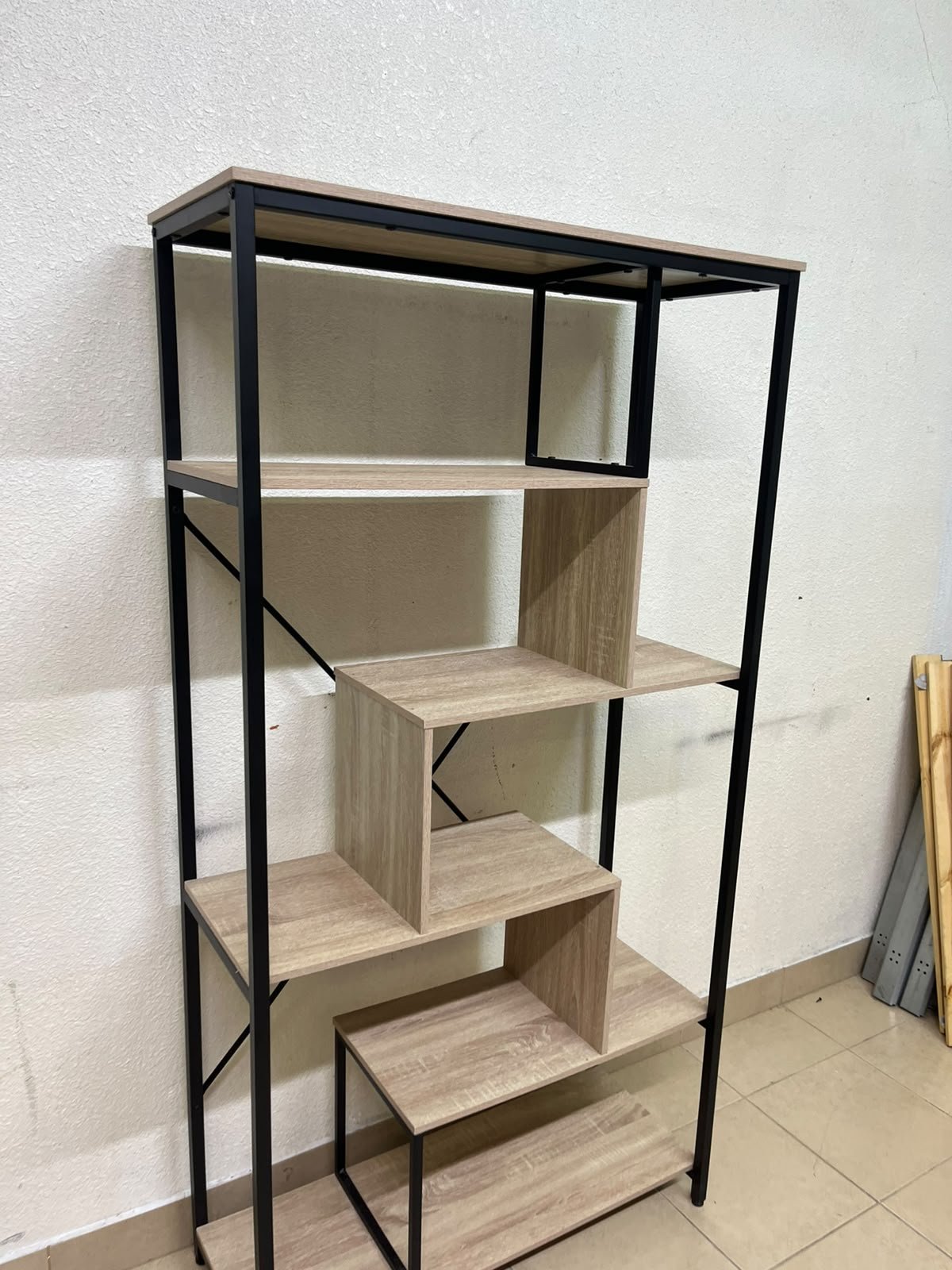 A shelving unit featuring a modern industrial design, consisting of a sturdy black metal frame and natural-look wooden shelves arranged in a tiered, graduated-width layout. - Image 5