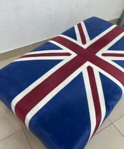 An Ottoman upholstered in luxurious velvet, featuring a vintage British flag design and metal stud detailing along the sides. - Image 3