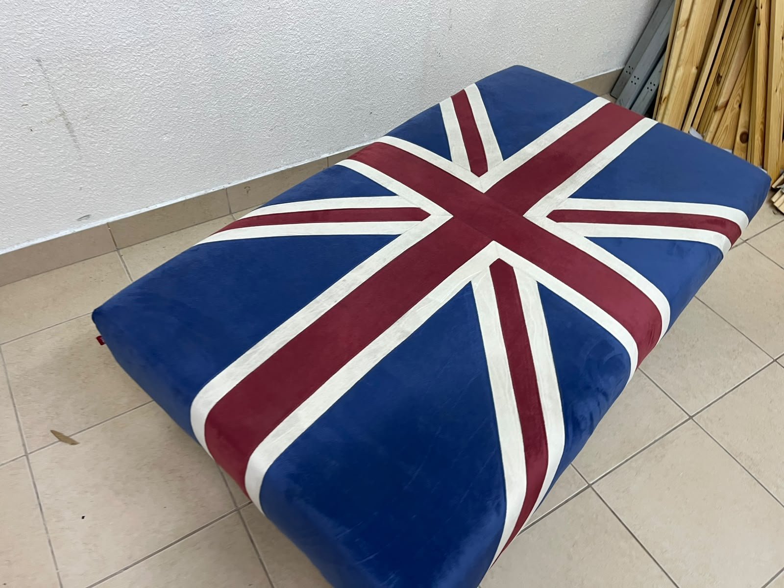 An Ottoman upholstered in luxurious velvet, featuring a vintage British flag design and metal stud detailing along the sides. - Image 3