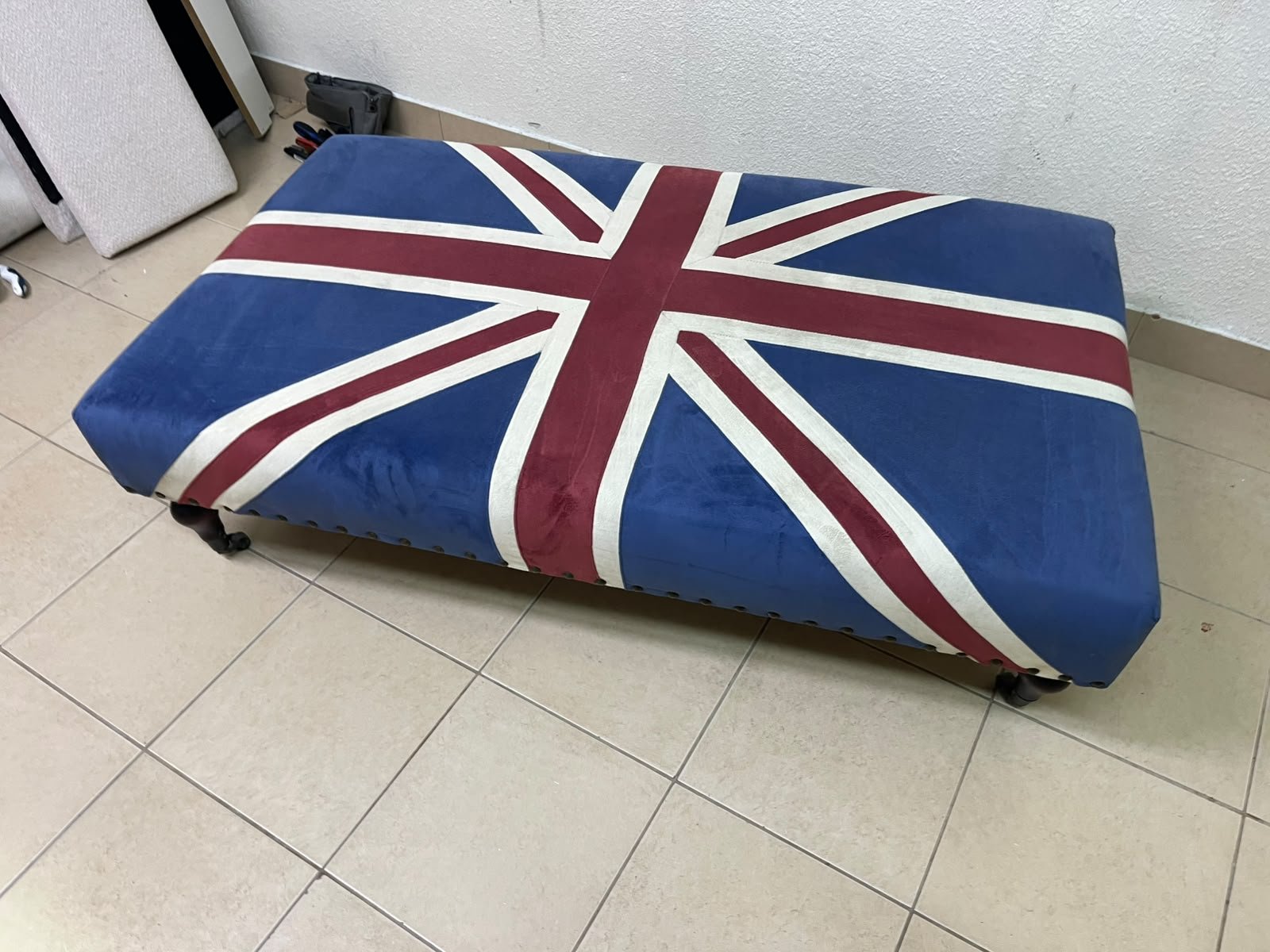 An Ottoman upholstered in luxurious velvet, featuring a vintage British flag design and metal stud detailing along the sides. - Image 6