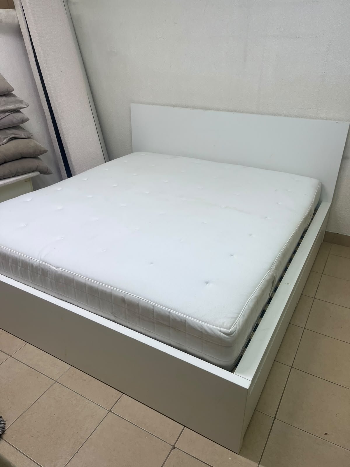 The bed is the high-frame MALM model from IKEA, featuring a white finish and practical under-bed drawers for storing bedding and clothing. - Image 9