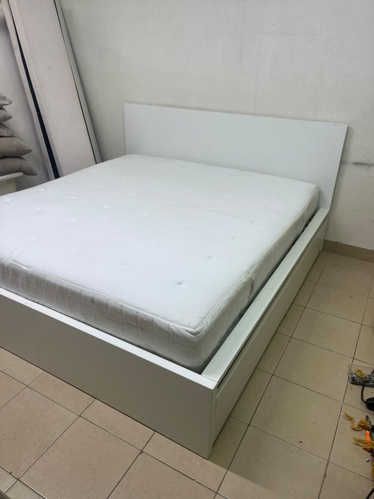 The bed is the high-frame MALM model from IKEA, featuring a white finish and practical under-bed drawers for storing bedding and clothing. - Image 10