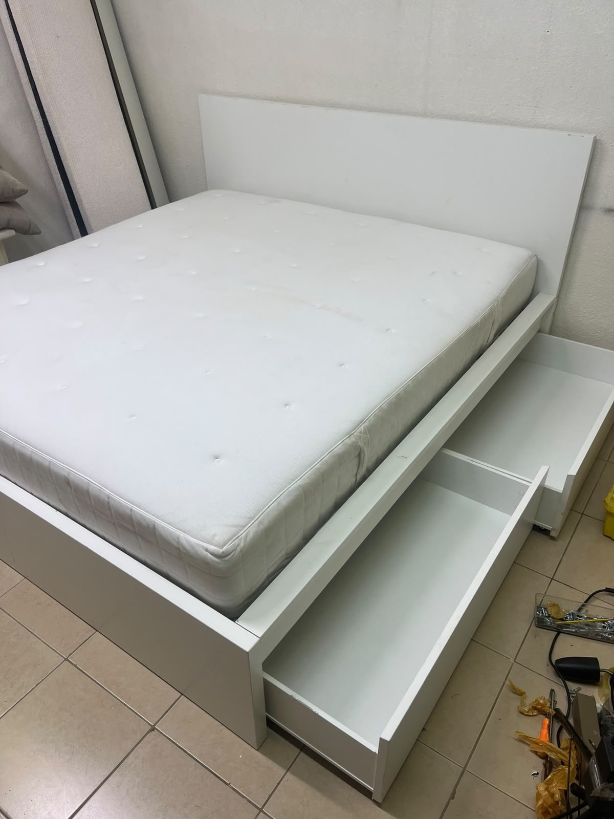 The bed is the high-frame MALM model from IKEA, featuring a white finish and practical under-bed drawers for storing bedding and clothing. - Image 11