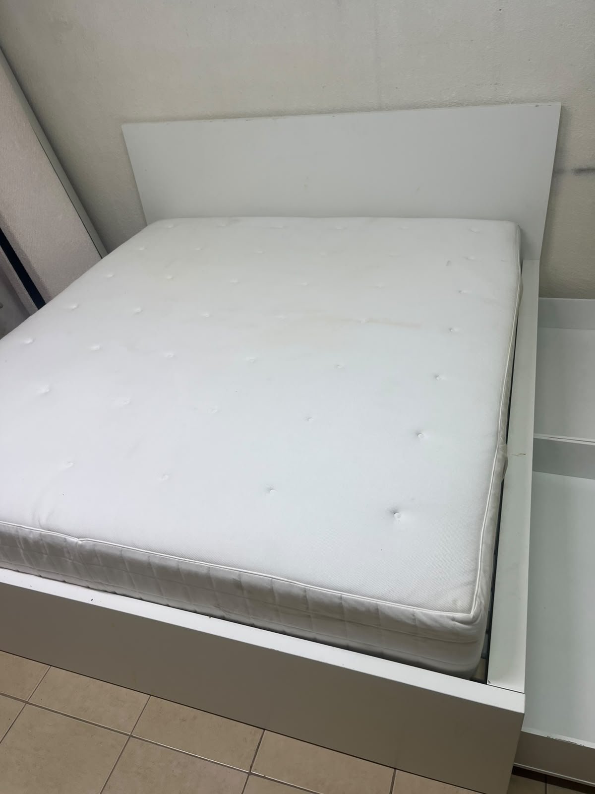 The bed is the high-frame MALM model from IKEA, featuring a white finish and practical under-bed drawers for storing bedding and clothing. - Image 12