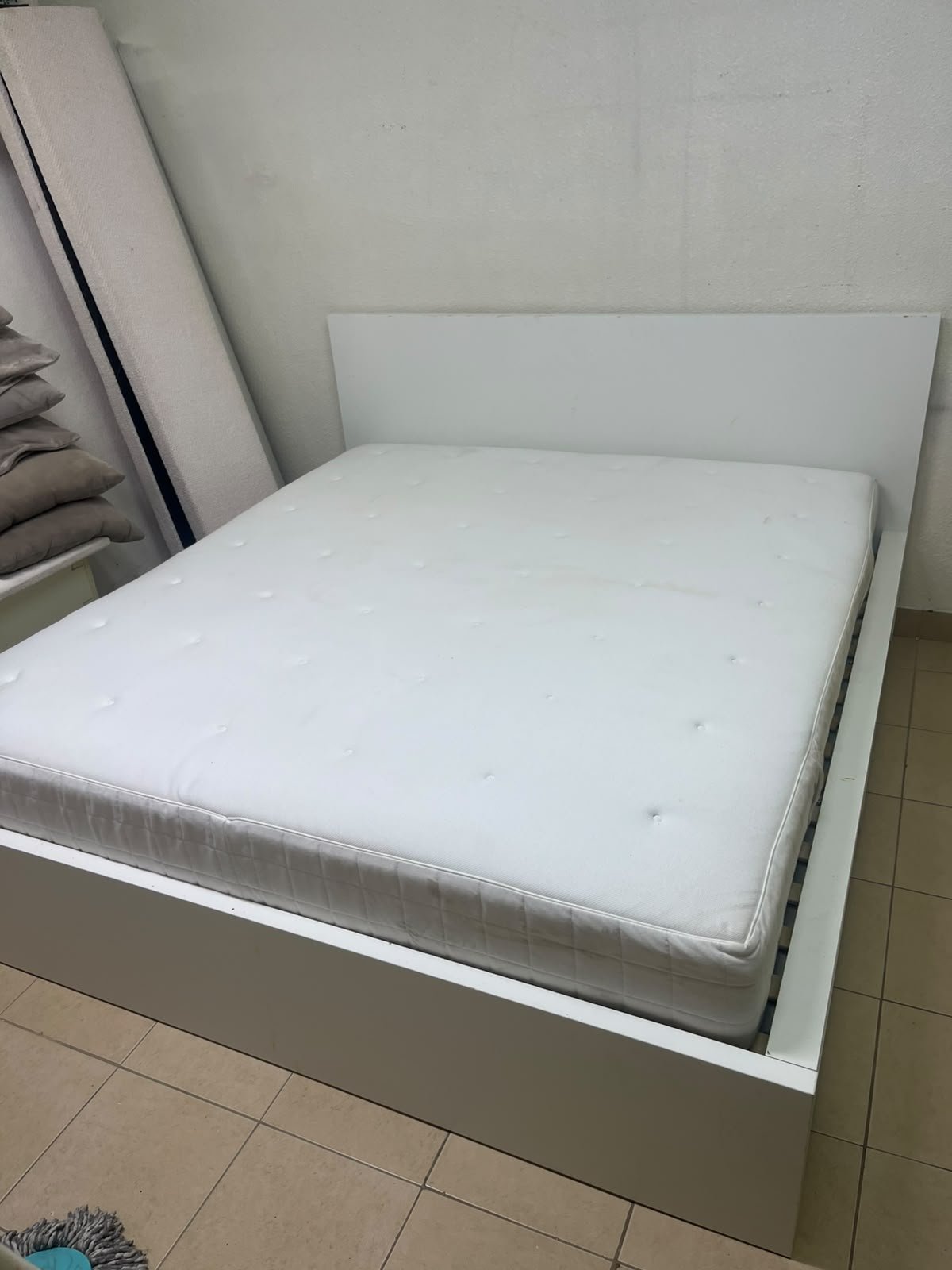 The bed is the high-frame MALM model from IKEA, featuring a white finish and practical under-bed drawers for storing bedding and clothing. - Image 13