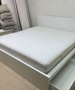 The bed is the high-frame MALM model from IKEA, featuring a white finish and practical under-bed drawers for storing bedding and clothing. - Image 7