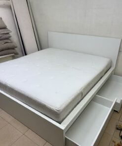 The bed is the high-frame MALM model from IKEA, featuring a white finish and practical under-bed drawers for storing bedding and clothing. - Image 4