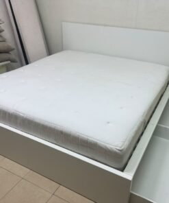 The bed is the high-frame MALM model from IKEA, featuring a white finish and practical under-bed drawers for storing bedding and clothing. - Image 3
