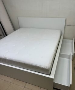 The bed is the high-frame MALM model from IKEA, featuring a white finish and practical under-bed drawers for storing bedding and clothing. - Image 2