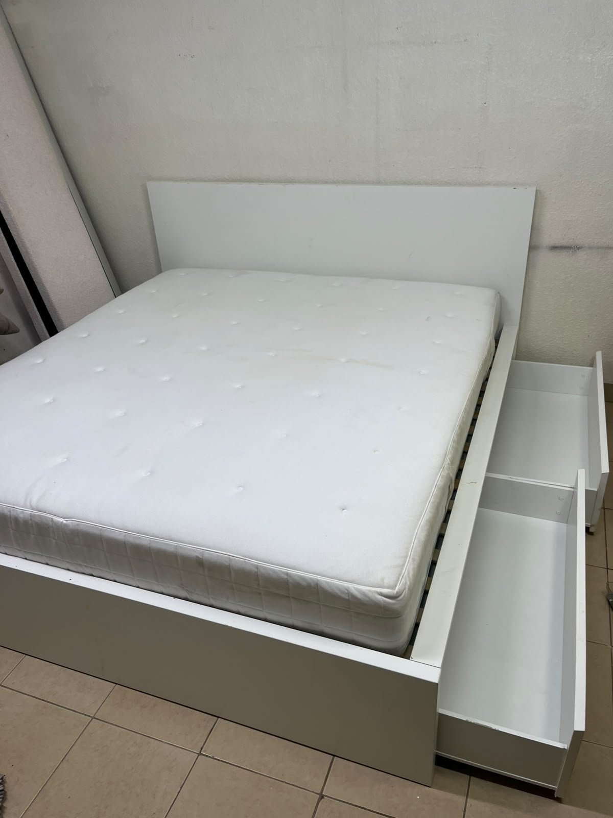 The bed is the high-frame MALM model from IKEA, featuring a white finish and practical under-bed drawers for storing bedding and clothing. - Image 2