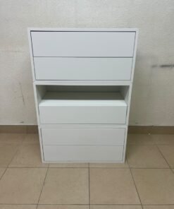 A white storage unit from IKEA’s EKET system, featuring a modular design that combines drawers with open storage space.