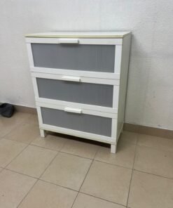 A white three-drawer chest with grey striped drawer fronts, similar to the IKEA Aneboda.