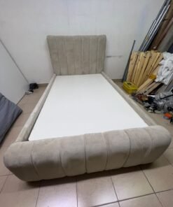 An elegantly designed, modern upholstered bed featuring a high headboard padded with prominent vertical lines and a curved footboard. - Image 2