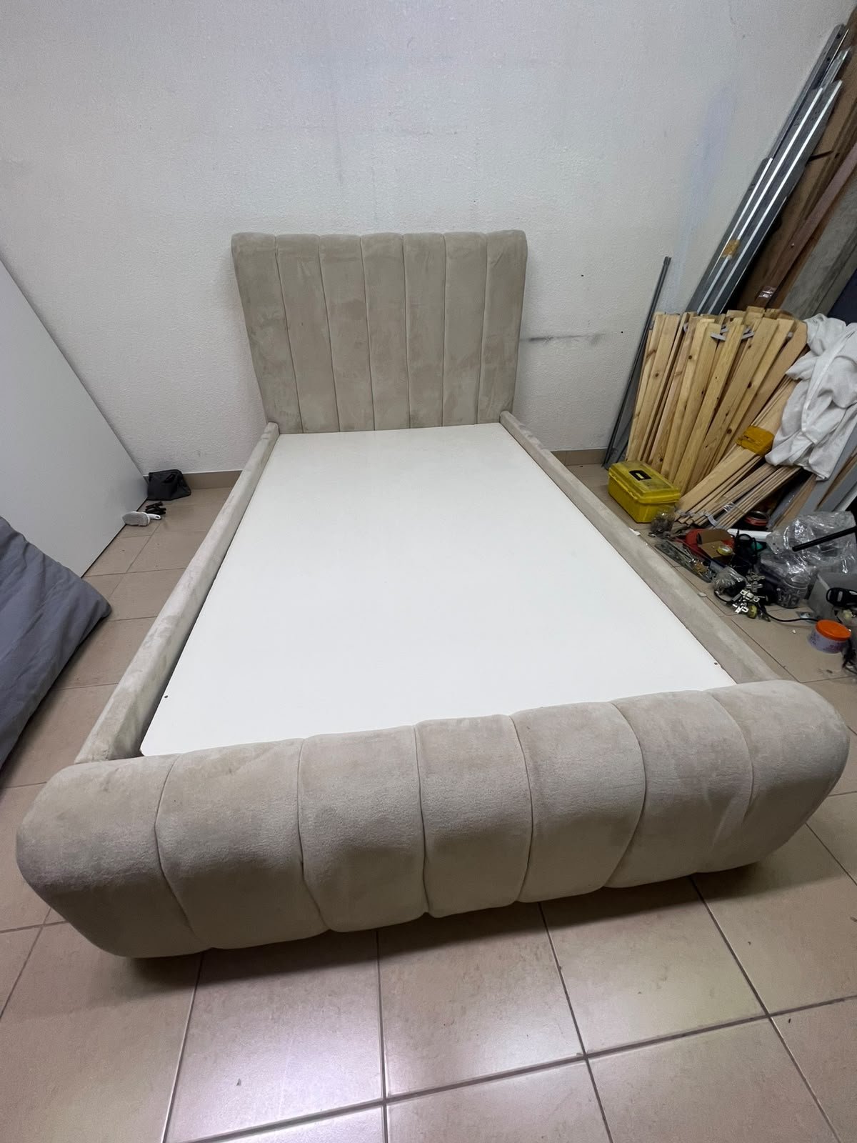 An elegantly designed, modern upholstered bed featuring a high headboard padded with prominent vertical lines and a curved footboard. - Image 2