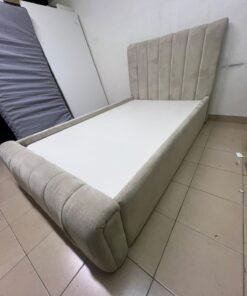 An elegantly designed, modern upholstered bed featuring a high headboard padded with prominent vertical lines and a curved footboard. - Image 3