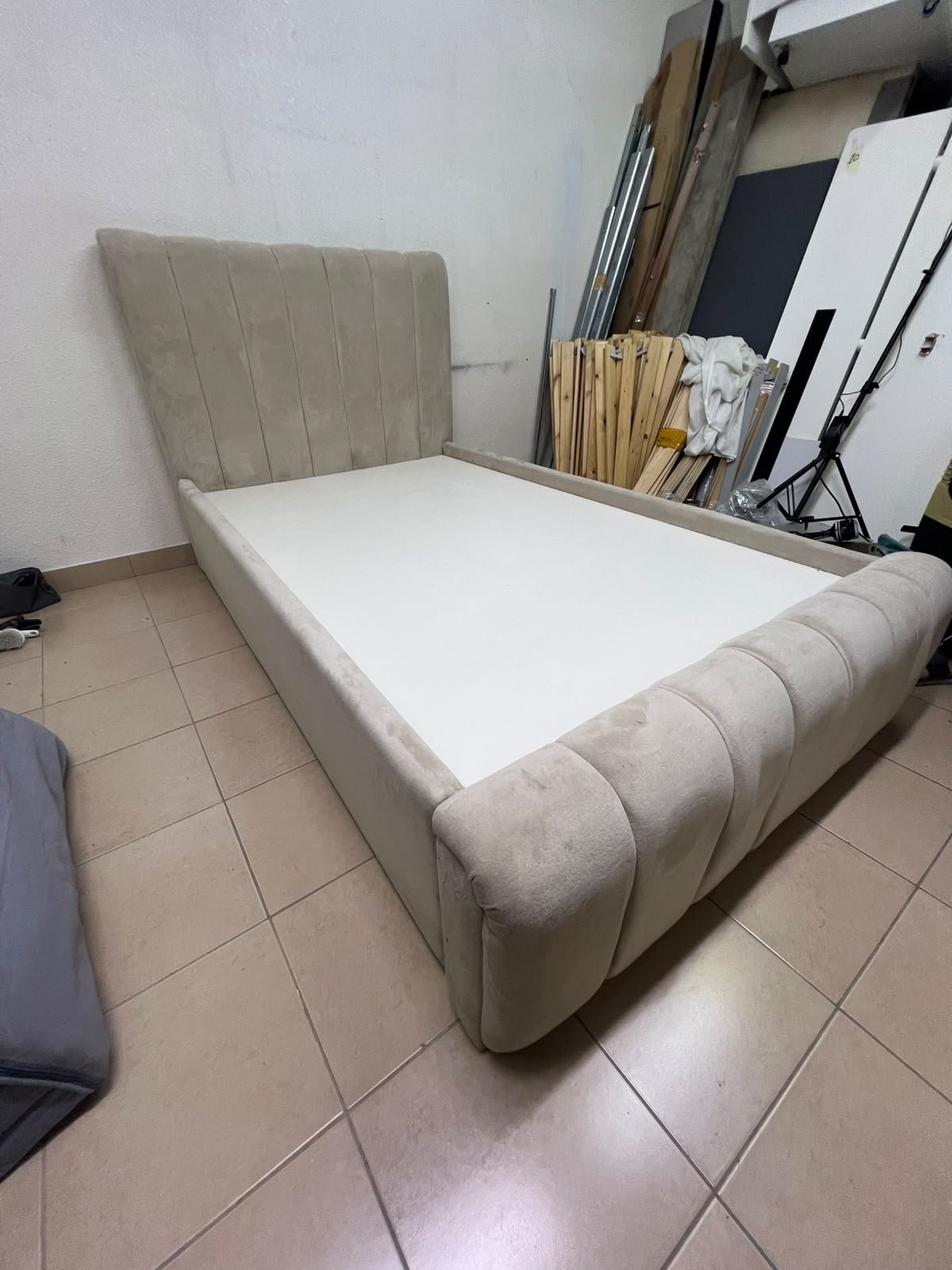 An elegantly designed, modern upholstered bed featuring a high headboard padded with prominent vertical lines and a curved footboard. - Image 4