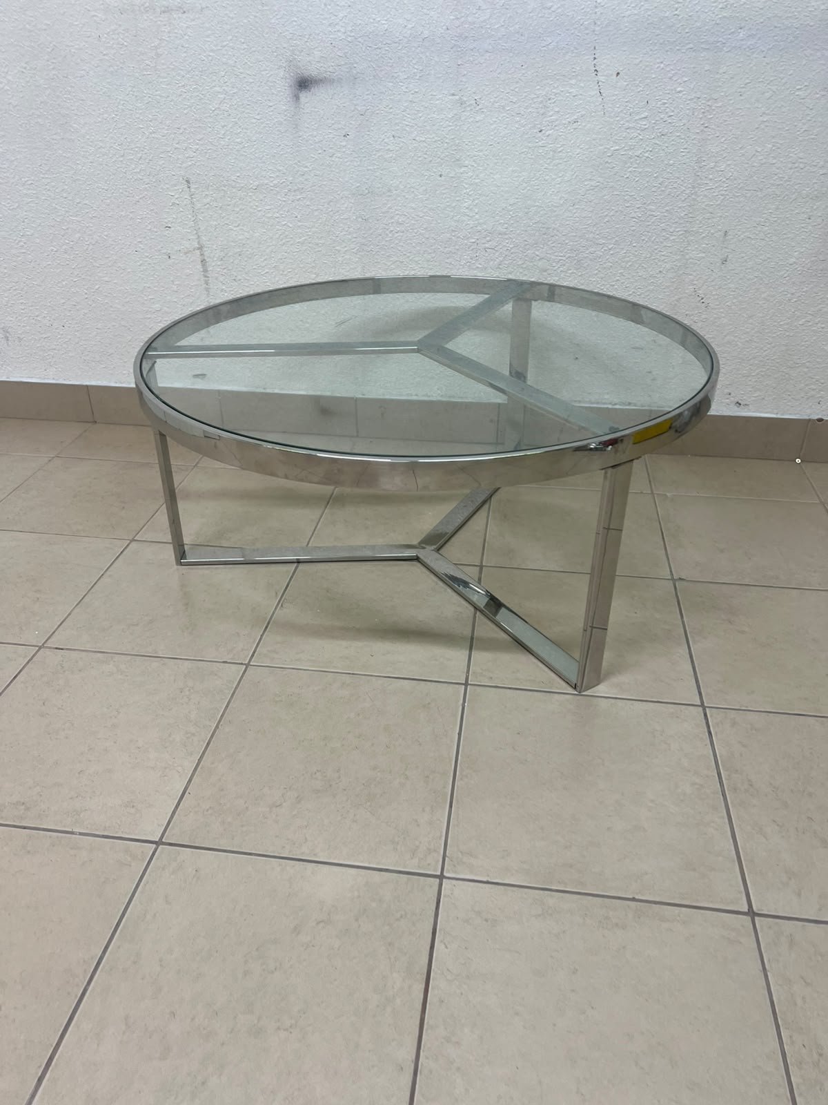 A round coffee table featuring a silver-colored metal frame (steel or chrome), a clear glass top, and a geometric crisscross base design. - Image 3