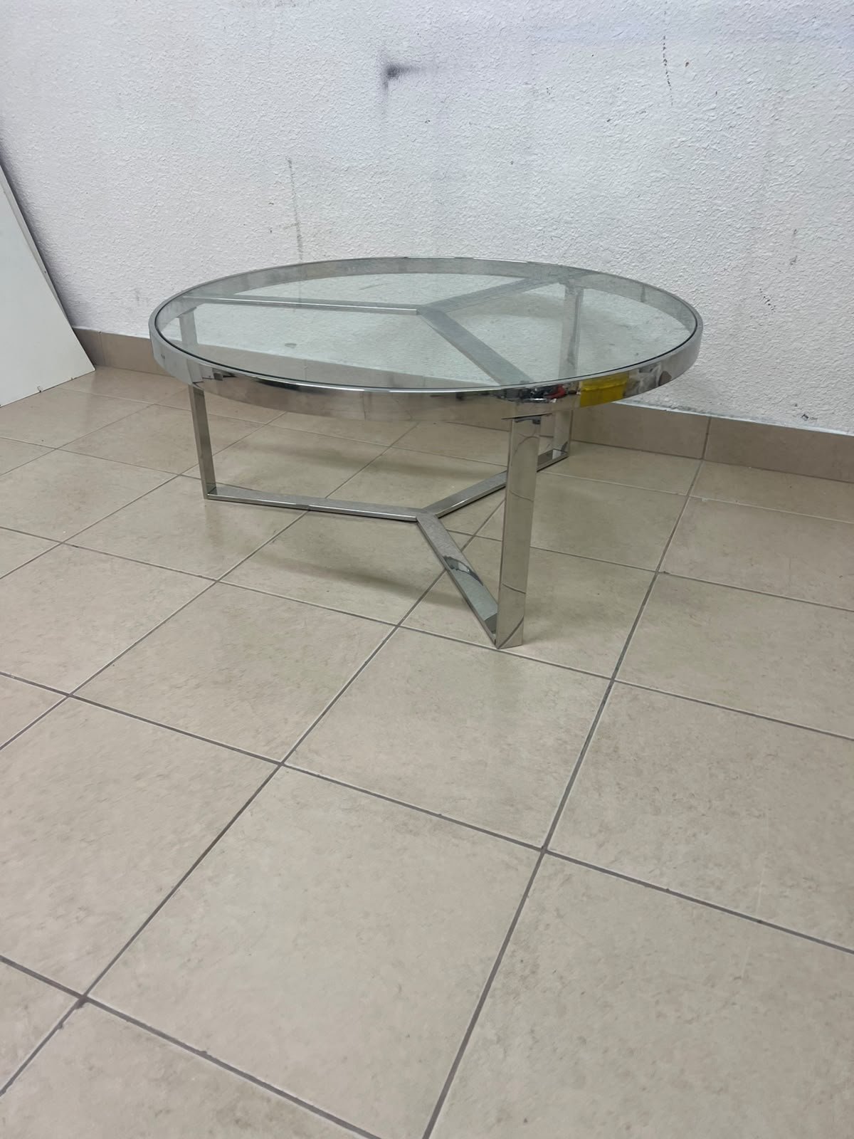 A round coffee table featuring a silver-colored metal frame (steel or chrome), a clear glass top, and a geometric crisscross base design. - Image 9