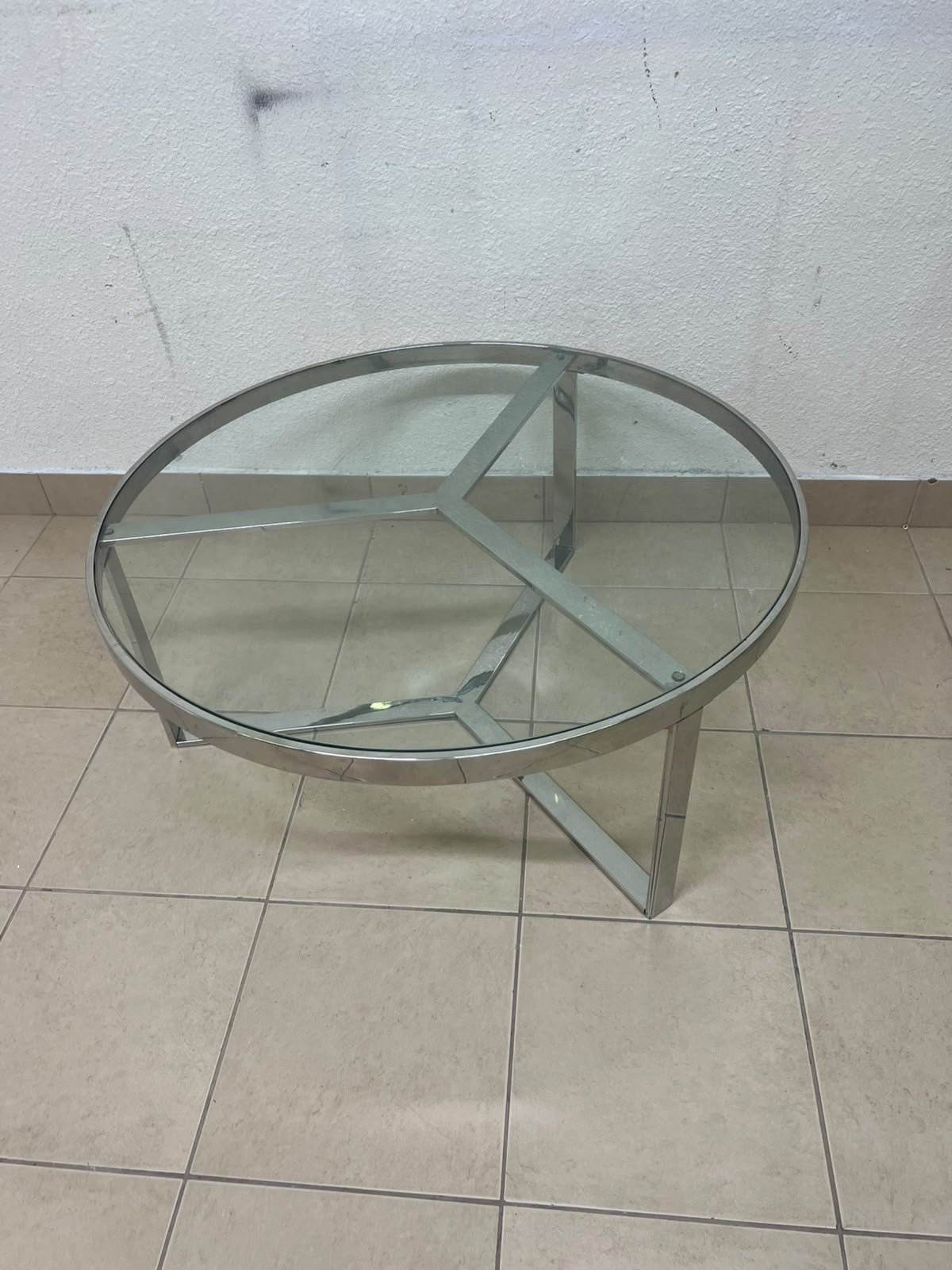A round coffee table featuring a silver-colored metal frame (steel or chrome), a clear glass top, and a geometric crisscross base design. - Image 8