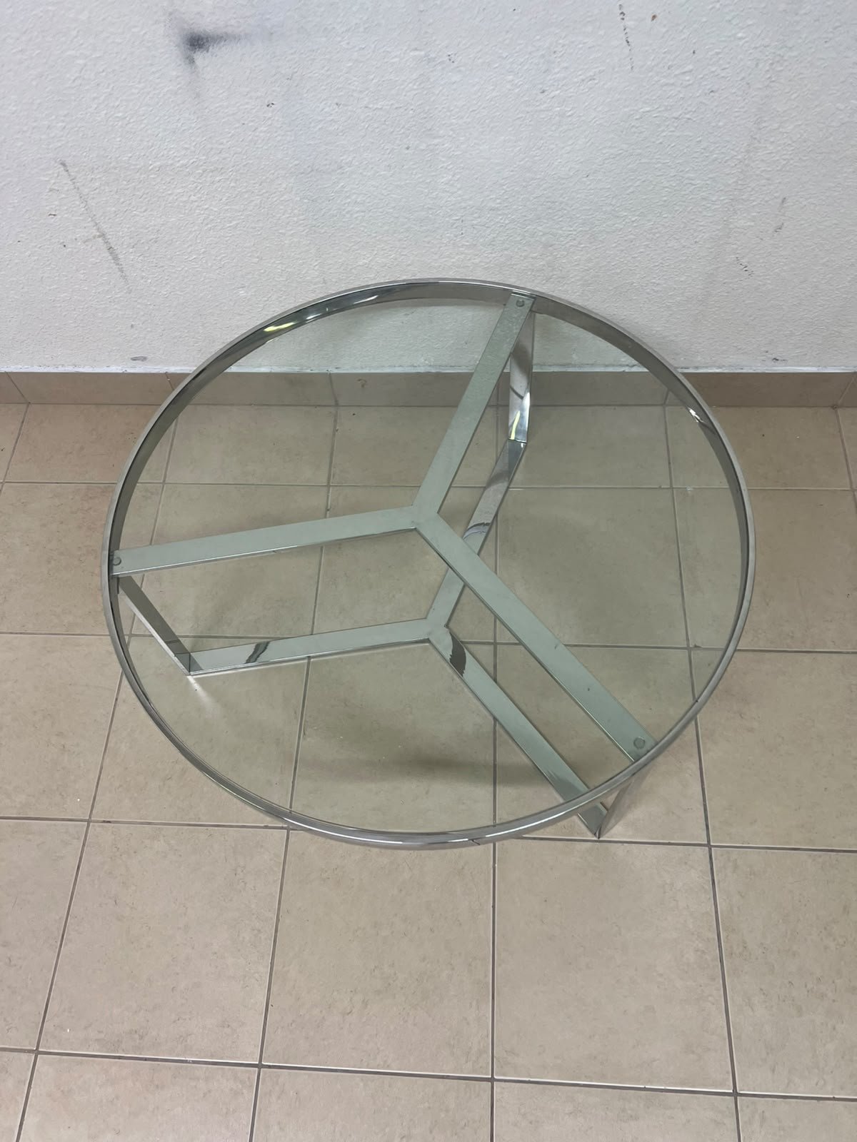 A round coffee table featuring a silver-colored metal frame (steel or chrome), a clear glass top, and a geometric crisscross base design. - Image 7