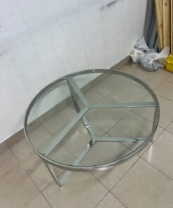 A round coffee table featuring a silver-colored metal frame (steel or chrome), a clear glass top, and a geometric crisscross base design. - Image 6