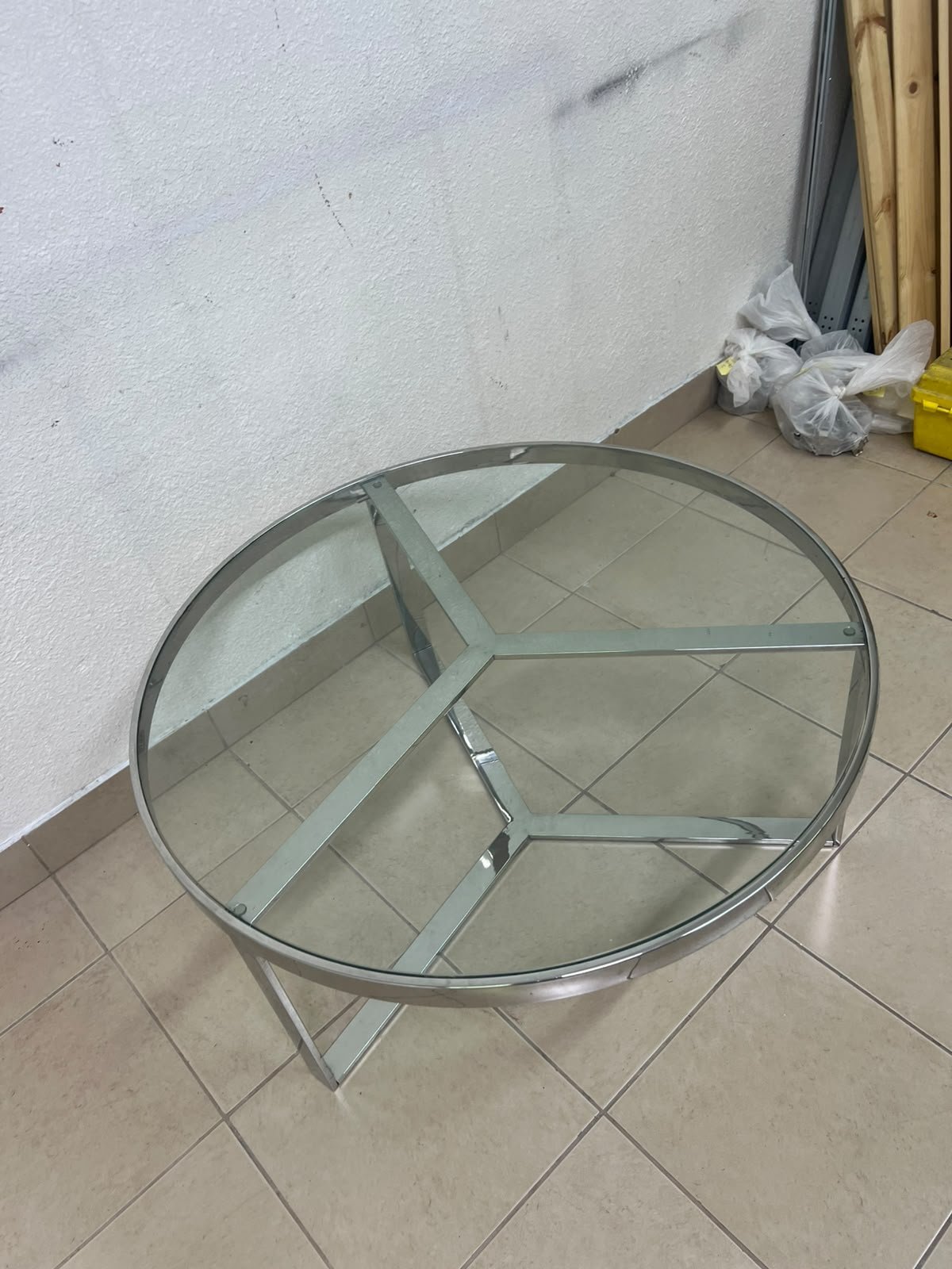 A round coffee table featuring a silver-colored metal frame (steel or chrome), a clear glass top, and a geometric crisscross base design. - Image 6