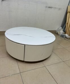 This round coffee table is elegant, featuring a cream-colored ribbed base and a stone tabletop with a marble-like pattern. - Image 2