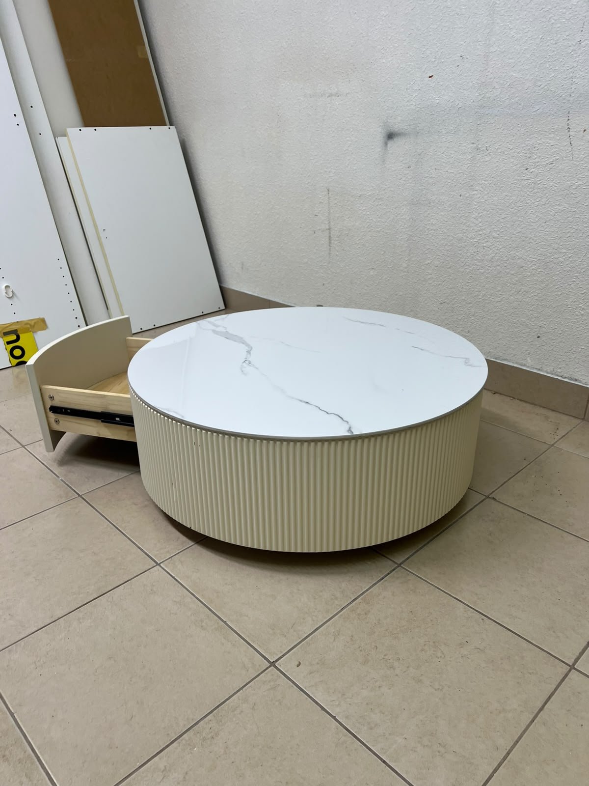 This round coffee table is elegant, featuring a cream-colored ribbed base and a stone tabletop with a marble-like pattern. - Image 7