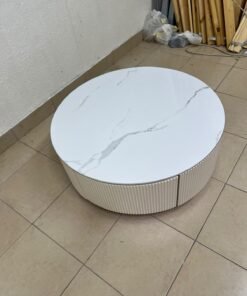 This round coffee table is elegant, featuring a cream-colored ribbed base and a stone tabletop with a marble-like pattern. - Image 9