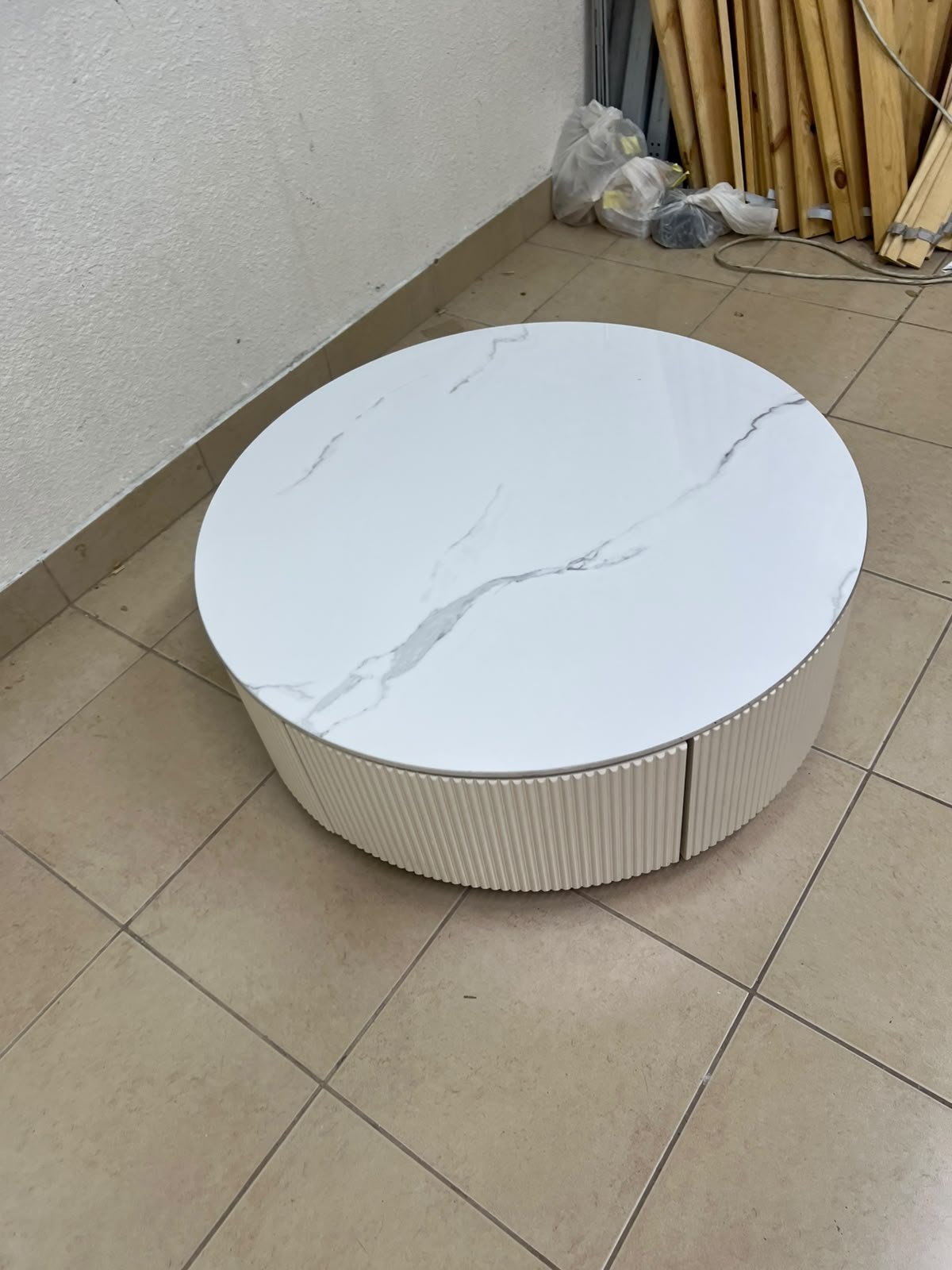 This round coffee table is elegant, featuring a cream-colored ribbed base and a stone tabletop with a marble-like pattern. - Image 9