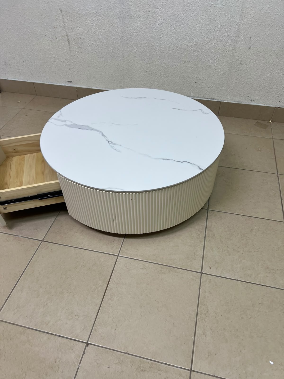 This round coffee table is elegant, featuring a cream-colored ribbed base and a stone tabletop with a marble-like pattern. - Image 10