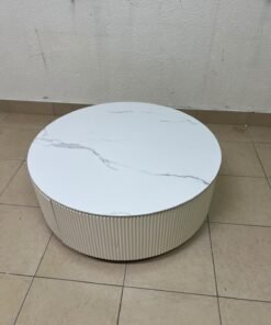 This round coffee table is elegant, featuring a cream-colored ribbed base and a stone tabletop with a marble-like pattern. - Image 11