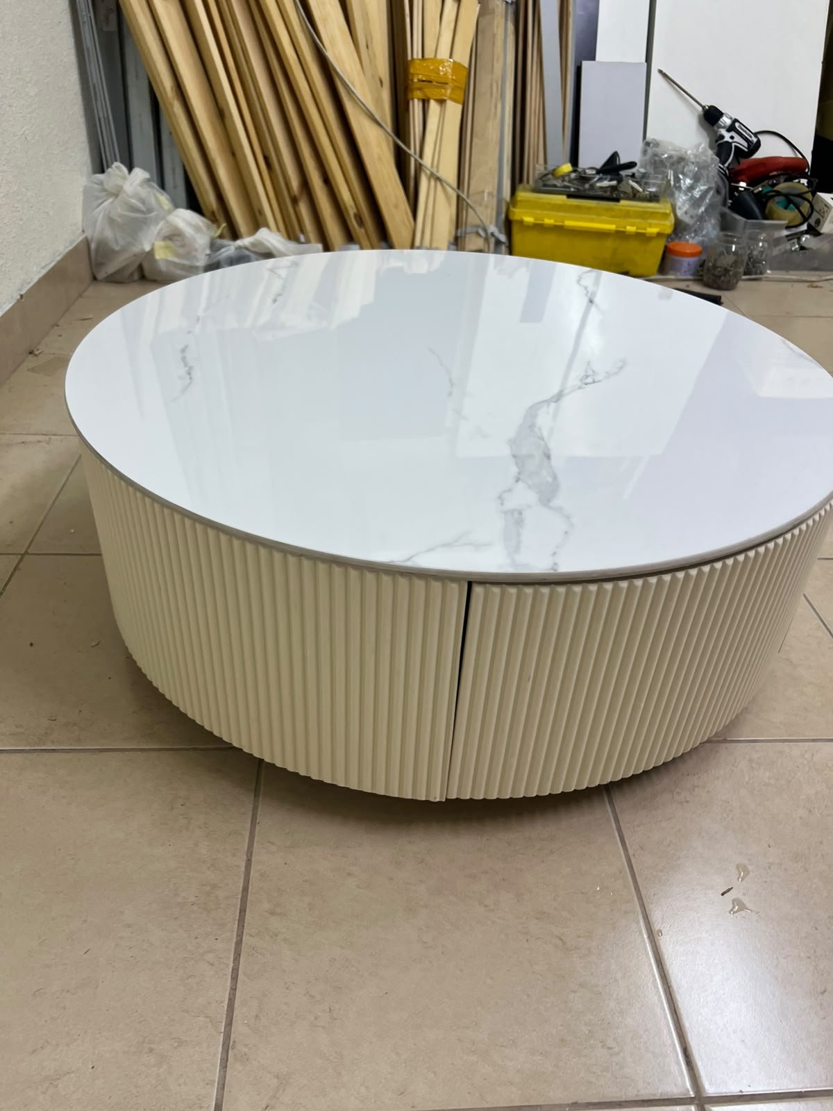 This round coffee table is elegant, featuring a cream-colored ribbed base and a stone tabletop with a marble-like pattern. - Image 4