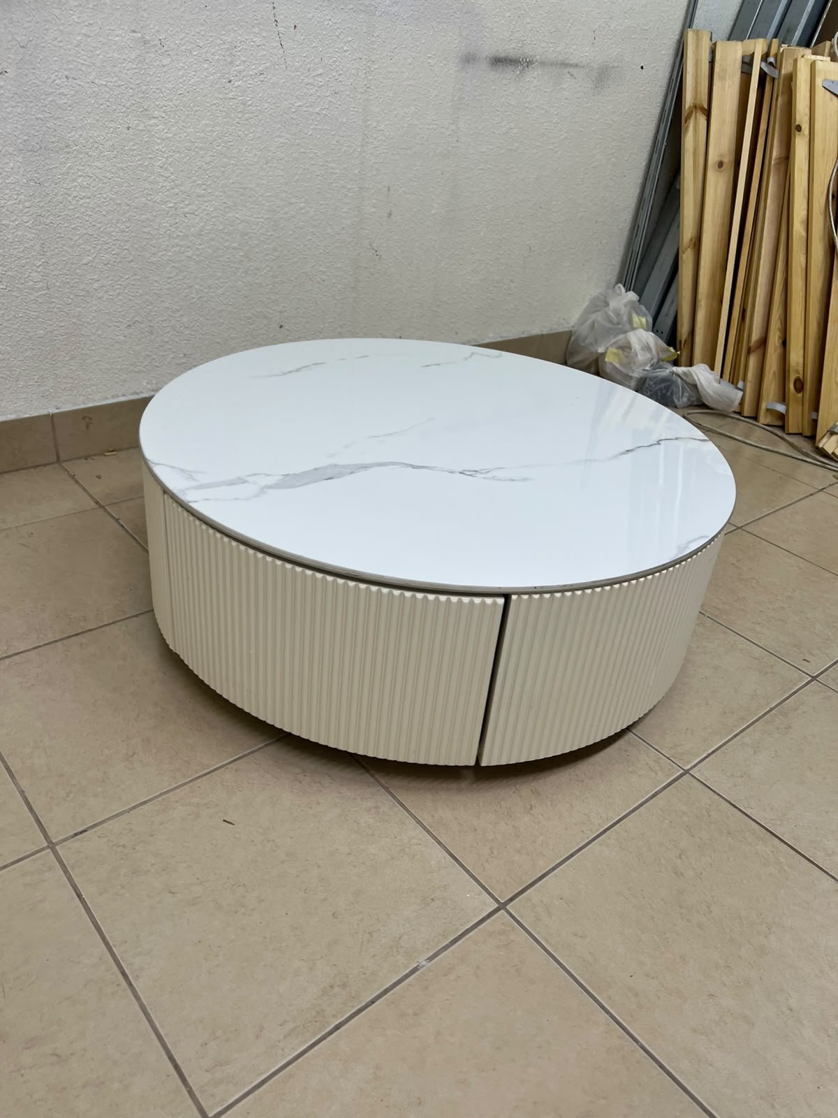 This round coffee table is elegant, featuring a cream-colored ribbed base and a stone tabletop with a marble-like pattern. - Image 5