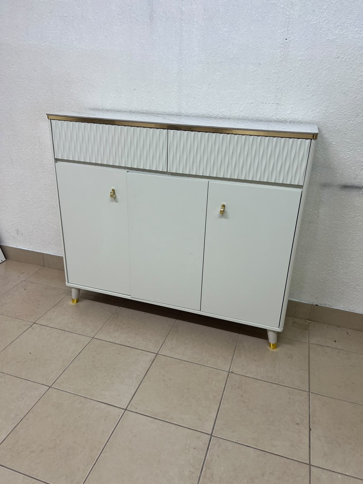 A white shoe cabinet or entryway storage unit (console) featuring a modern design, ribbed upper drawers, and gold accents on the handles and legs. - Image 3