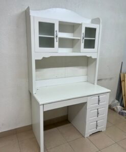 A complete white study desk featuring an overhead hutch, distinguished by its upper cabinets with glass doors and decorative handles.