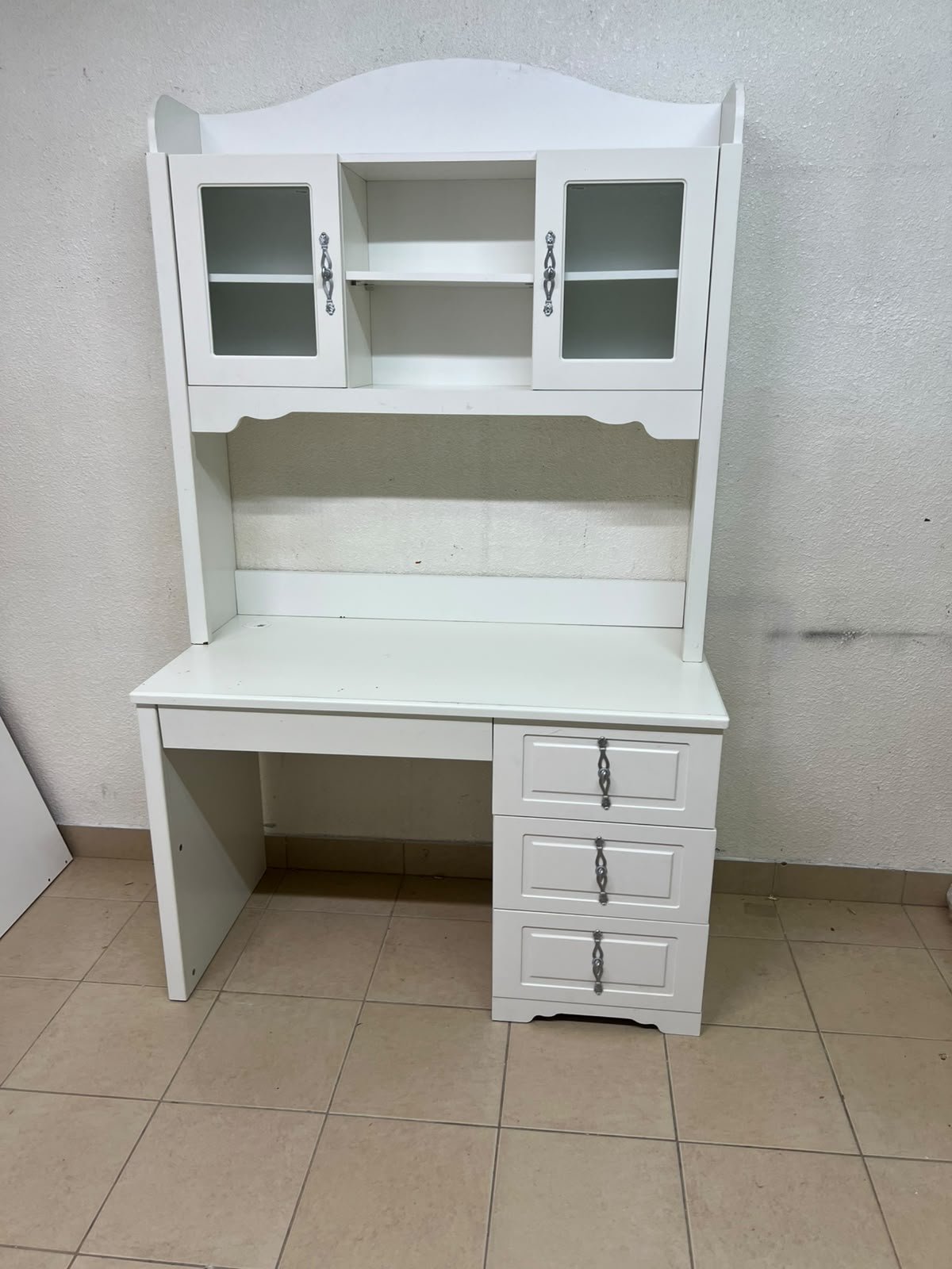 A complete white study desk featuring an overhead hutch, distinguished by its upper cabinets with glass doors and decorative handles. - Image 4