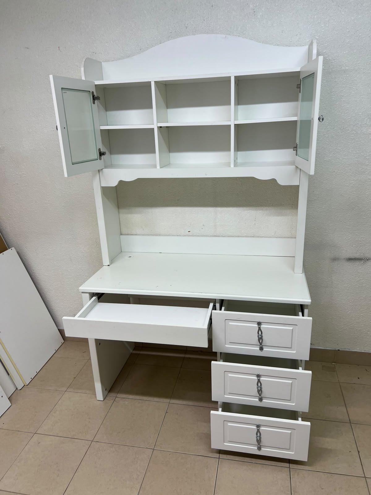 A complete white study desk featuring an overhead hutch, distinguished by its upper cabinets with glass doors and decorative handles. - Image 10