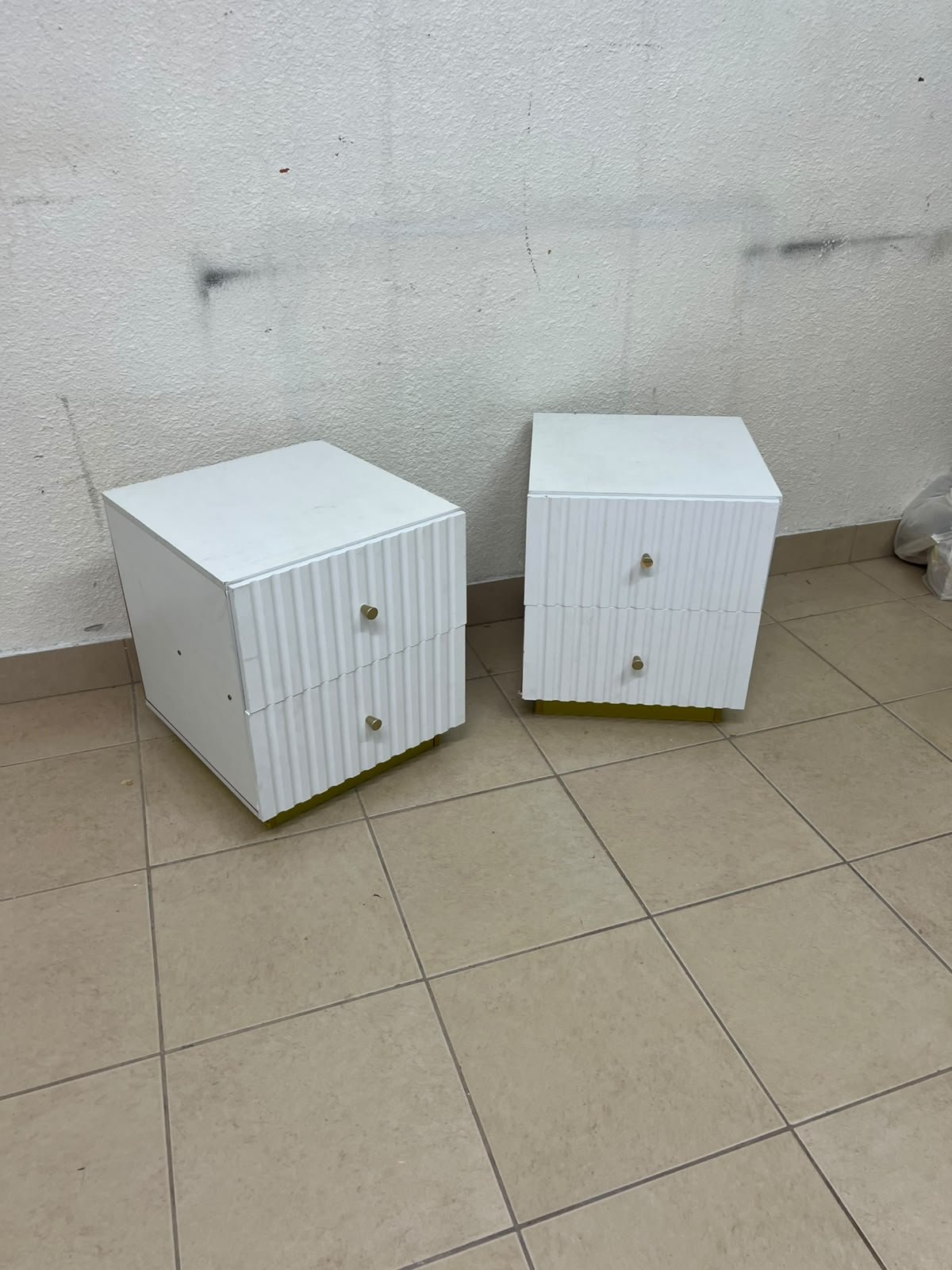 Modern white bedside tables featuring an elegant vertical ribbed design, with attractive gold accents on the handles and base. - Image 6