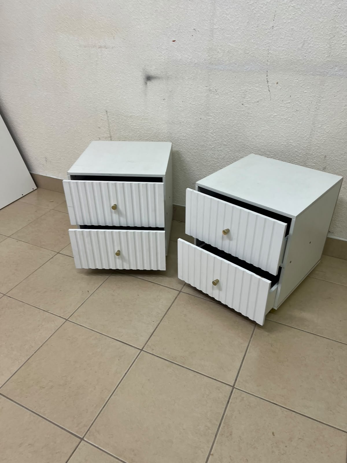 Modern white bedside tables featuring an elegant vertical ribbed design, with attractive gold accents on the handles and base. - Image 7
