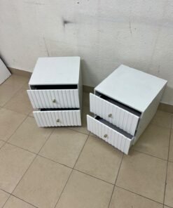 Modern white bedside tables featuring an elegant vertical ribbed design, with attractive gold accents on the handles and base. - Image 2