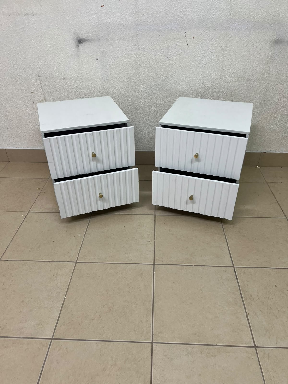 Modern white bedside tables featuring an elegant vertical ribbed design, with attractive gold accents on the handles and base. - Image 4