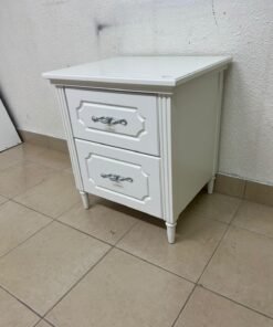 The elegant white side table with two drawers is distinguished by its decorative details and prominent silver handles. - Image 3