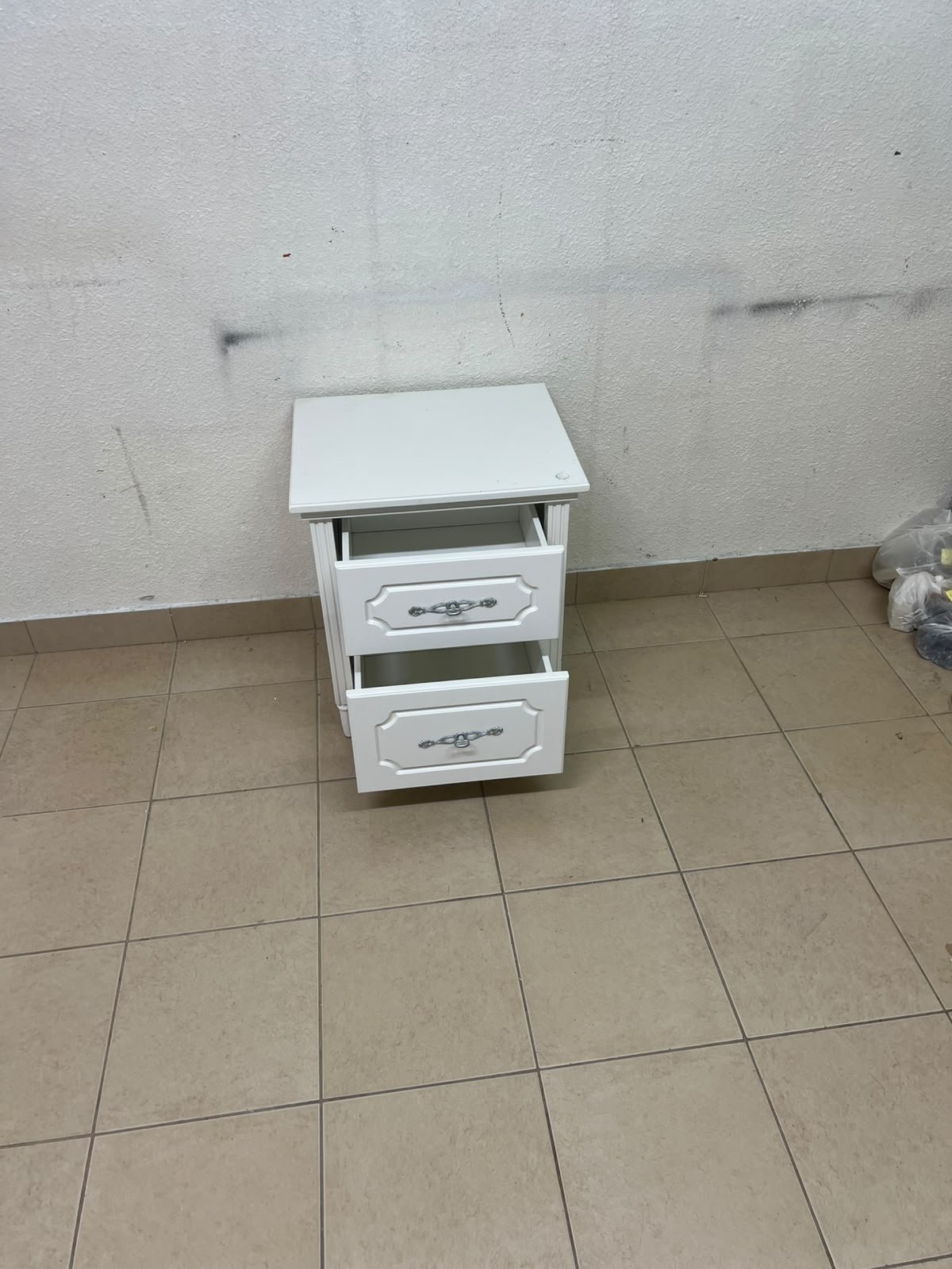 The elegant white side table with two drawers is distinguished by its decorative details and prominent silver handles. - Image 5