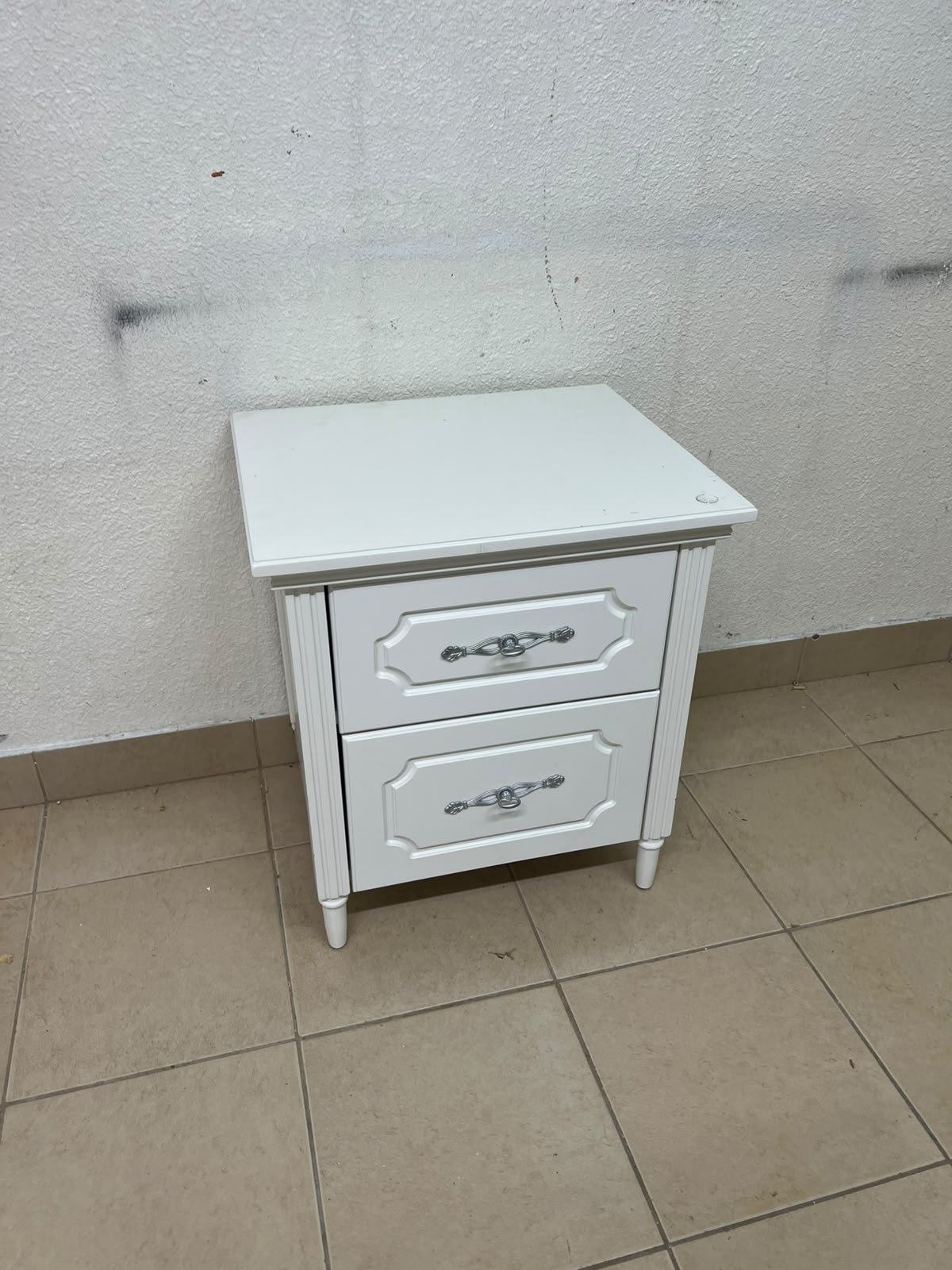 The elegant white side table with two drawers is distinguished by its decorative details and prominent silver handles. - Image 7