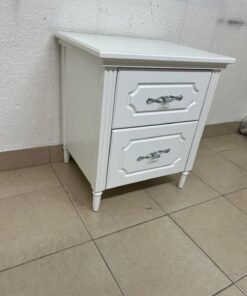 The elegant white side table with two drawers is distinguished by its decorative details and prominent silver handles. - Image 9