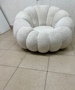 The Fana "Flower" chair from Home Centre is a lounge chair featuring a floral-inspired design and upholstered in soft, comfortable bouclé fabric; it is distinguished by its rounded shape—resembling petals or a pumpkin. - Image 3