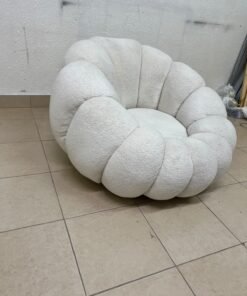 The Fana "Flower" chair from Home Centre is a lounge chair featuring a floral-inspired design and upholstered in soft, comfortable bouclé fabric; it is distinguished by its rounded shape—resembling petals or a pumpkin. - Image 4