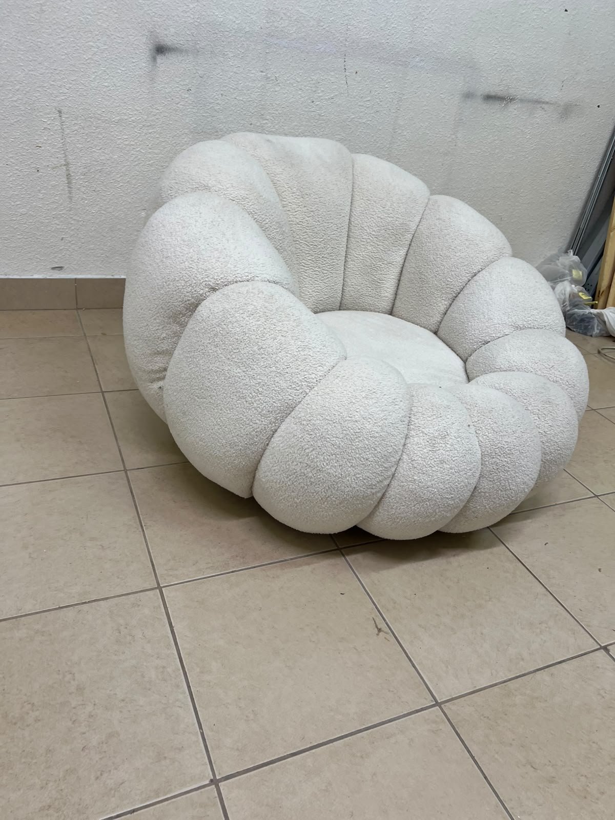 The Fana "Flower" chair from Home Centre is a lounge chair featuring a floral-inspired design and upholstered in soft, comfortable bouclé fabric; it is distinguished by its rounded shape—resembling petals or a pumpkin. - Image 4